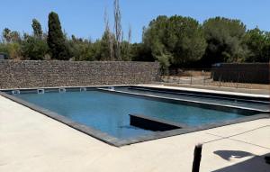 a swimming pool in a yard with a brick wall at Luxury Cottage Sauna&Pool at CapDAgde in Agde