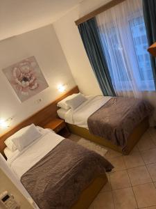 a hotel room with two beds and a window at Hotel Žućo in Biograd na Moru +2 photos