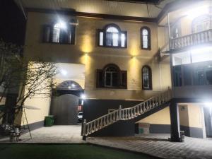 a building with a staircase in front of it at night at Boston Grand hotel in Osh
