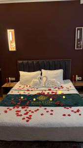 a bed with flowers on it with two swans on it at Boston Grand hotel in Osh