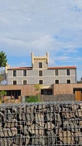 a large building behind a stone wall at Luxury Cottage Sauna&Pool at CapDAgde in Agde