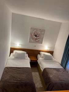 two beds in a small room with at Hotel Žućo in Biograd na Moru