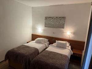 two beds in a small room with at Hotel Žućo in Biograd na Moru