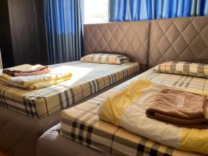 zwei Betten, die in einem Zimmer nebeneinander stehen in der Unterkunft Popular Condo by Jintana in Pak Kret
