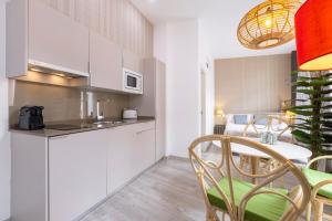 a kitchen and dining room with a table and chairs at Apartamentos Soho Boutique Museo in Málaga