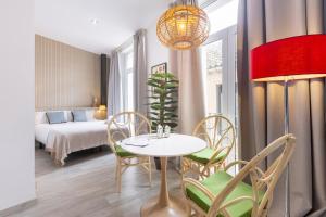 a room with a table and chairs and a bed at Apartamentos Soho Boutique Museo in Málaga
