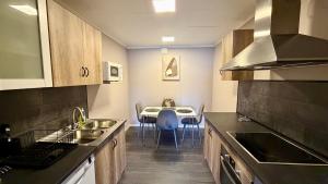 a kitchen with a sink and a table with chairs at Arctic Dream in Gratangen