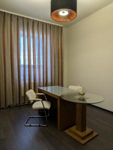 a dining room with a glass table and two chairs at MARISS hotel & business in Kropyvnytskyi