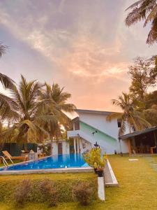 a house with a swimming pool and palm trees at Sky Vista by Jonathan's way in Negombo