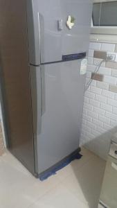 a silver refrigerator in a kitchen with a wall at Share Apartment but Private Room in Madinat Al Ashir min Ramadan