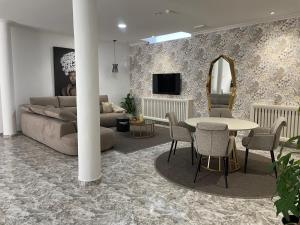 a living room with a couch and a table and chairs at Hotel Playa Compostela in Vilagarcia de Arousa