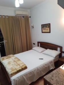 a bedroom with a bed with white sheets at Studio de luxe avec piscine in Tétouan
