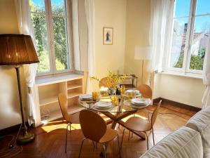 a living room with a glass table and chairs at Emy charming apartment with pool in Verbania