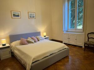 a bedroom with a bed with pillows and a window at Emy charming apartment with pool in Verbania
