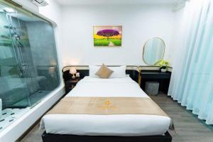 a bedroom with a large bed and a shower at HoangAnh Hotel in Ha Long