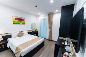 a hotel room with a bed and a tv at HoangAnh Hotel in Ha Long