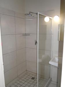 a shower with a glass door next to a sink at Colesberg Lodge in Colesberg