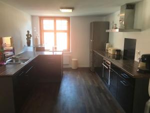 a kitchen with black counters and a large window at Ferienwohnungen Haus Castello App9 in Aschau im Chiemgau +2 photos