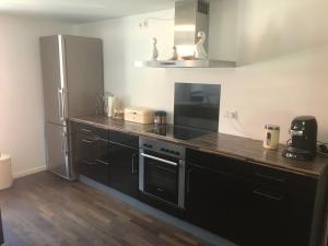 a kitchen with black cabinets and a stainless steel refrigerator at Ferienwohnungen Haus Castello App9 in Aschau im Chiemgau