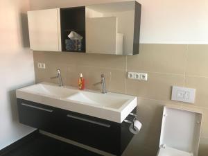 a bathroom with a white sink and a toilet at Ferienwohnungen Haus Castello App9 in Aschau im Chiemgau