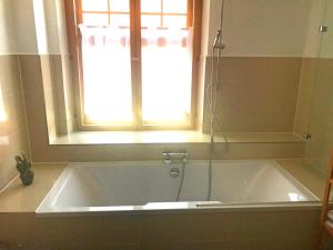 a bath tub in a bathroom with a window at Ferienwohnungen Haus Castello App9 in Aschau im Chiemgau