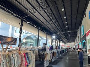 Eine Gruppe von Menschen, die mit Kleidung durch einen Markt gehen in der Unterkunft Popular Condo by Jintana in Pak Kret