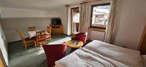a hotel room with a bed and a table and chairs at Frühstückspension Schönblick in Ellmau