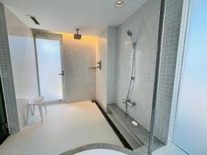 a bathroom with a shower and a glass door at Auberge de Oishi in Takamatsu