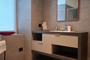 a bathroom with a sink and a mirror at Appartamento Caffaro Vacanza in Ponte Caffaro +12 photos