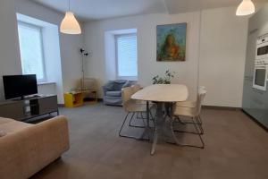 a living room with a table and a couch at Appartamento Caffaro Vacanza in Ponte Caffaro