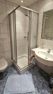 a bathroom with a shower and a sink and a toilet at Frühstückspension Schönblick in Ellmau +32 photos