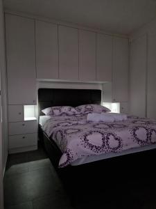a bedroom with a bed with a purple comforter at Stan na dan - Brcko 1 in Brčko