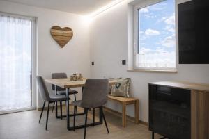 a living room with a table and chairs and a heart on the wall at MOUNTAIN HOME Fiemme - Nuovo, Balconi e Garage in Castello di Fiemme
