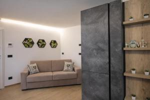 a living room with a couch and a wall at MOUNTAIN HOME Fiemme - Nuovo, Balconi e Garage in Castello di Fiemme