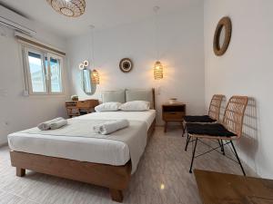 a bedroom with a large bed and a chair at Theodora Rooms in Kamares