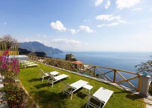 a group of chairs sitting on the grass near the water at Borgo Sant'Anna in Amalfi