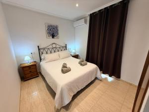 a bedroom with a bed with two stuffed animals on it at Urbanización Torremar Natura in Vera +49 photos