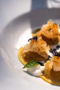 a white plate with food on a white table at La Pietra Del Cabreo in Greve in Chianti