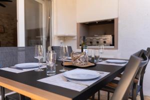 a table with plates and glasses on top of it at Laurentina - Modern Apartment with Large Terrace near Beach-quiet and comfortable in Sutivan +19 photos