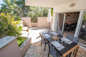 a patio with a table and chairs and an umbrella at Laurentina - Modern Apartment with Large Terrace near Beach-quiet and comfortable in Sutivan