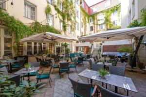 an outdoor patio with tables and chairs and umbrellas at martas Hotel Allegra Berlin in Berlin