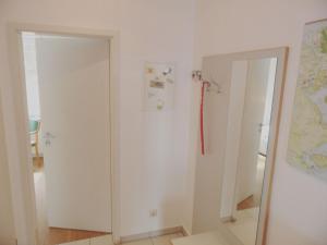 a bathroom with two white cabinets and a mirror at Ferienwohnungen direkt am Schmollensee in Bansin