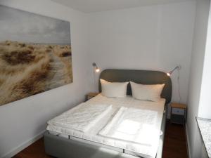 a bedroom with a bed with a painting on the wall at Ferienwohnungen direkt am Schmollensee in Bansin