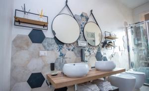 a bathroom with two sinks and mirrors on the wall at Come a Casa Pretty Apartment in Lido di Ostia +49 photos