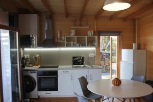 a kitchen with a table and a stove and a refrigerator at Casa da Camélia in São Roque do Pico
