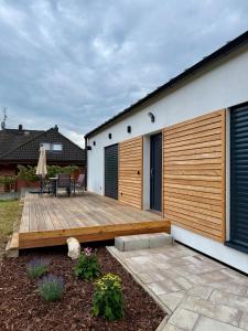 a backyard with a wooden deck next to a house at Domeček U Potoka in České Budějovice