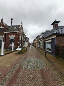 a cobblestone street in a town with houses at Studio 13 in Dronrijp