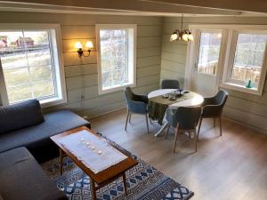 a living room with a couch and a table and chairs at Melkevoll Bretun Camping in Briksdalsbre