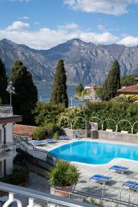 a swimming pool with a view of the mountains at Hotel Excelsior Bay in Malcesine