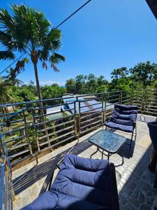 a patio with two chairs and a table and a palm tree at Island Nest in Virac
